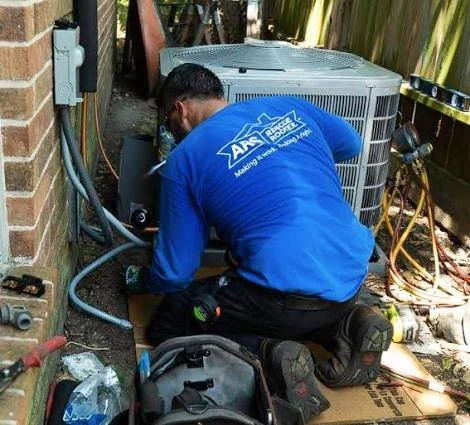 Technician repairing the connections on a residential outdoor air conditioner