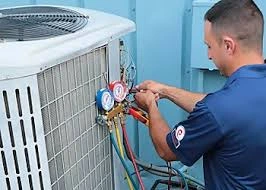HVAC technician checking refrigerant pressure gauges on a cooling system