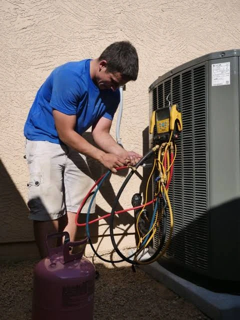 HVAC professional checking an outdoor cooling system with service gauges